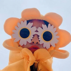 Detail shot of fun daisy shaped sunglasses paired with a bright orange floral hoodie