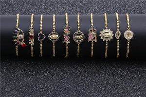 Close-up of gold-plated bracelets with colorful cubic zirconia and evil eye charms