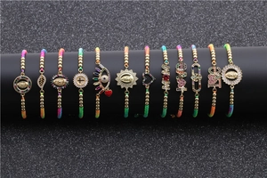 Macro shot of colorful evil eye charms and golden beads on braided cord bracelets