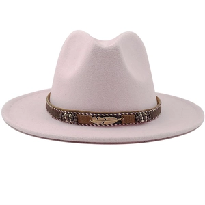 Detail of light pink fedora hat featuring a woven band and golden feather pendant
