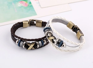 Close-up of brown and white layered leather bracelets with X-shaped metal studs