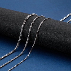 Polished silver stainless steel wheat and rope chain necklaces on black display stand