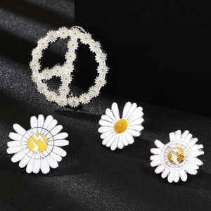 Détails macro de broches marguerites en émail avec motifs de paix et d'éclairs