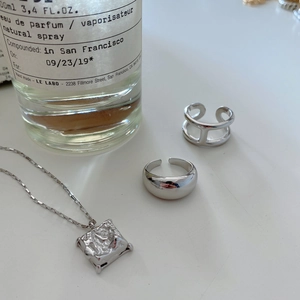 Detailed close-up of 925 sterling silver geometric rings and square textured pendant