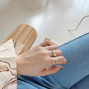 Macro detail of 925 silver rings with minimalist H letter cutout design on a model