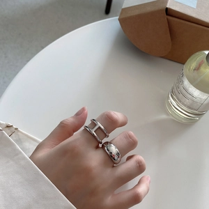 Close-up of a silver 925 minimalist letter H open ring and smooth wide band ring set