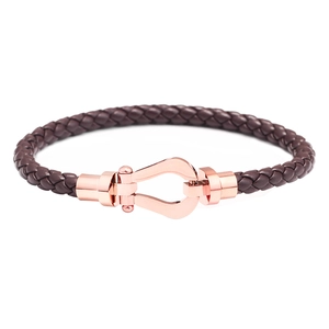 Détail du bracelet en cuir tressé marron foncé et fermoir fer à cheval or rose