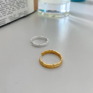 Detail of minimalist S925 silver rings with irregular gold foil texture surface