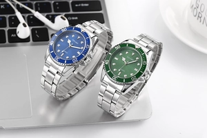 Detailed view of stylish men's quartz watches with blue and green dials on a laptop