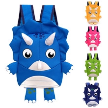Detail view of colorful cartoon triceratops backpacks in blue, pink, and green colors
