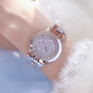 Luxurious women's silver watch with full rhinestone inlay and metal strap on model wrist