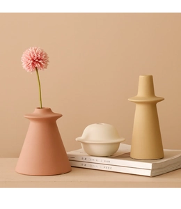 Detailed view of matte Morandi ceramic vases set on magazines for home decor