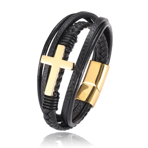 Detail of multi-layer black leather bracelet with gold cross and magnetic clasp