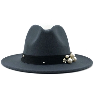 Detail eines dunkelgrauen Fedora-Hutes mit schwarzem Ripsband und weißen Perlenakzenten