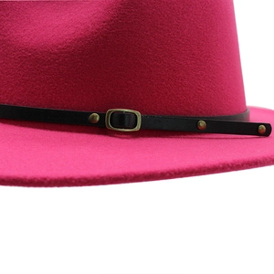 Detail of rose red fedora hat with black leather belt and vintage bronze metal buckle