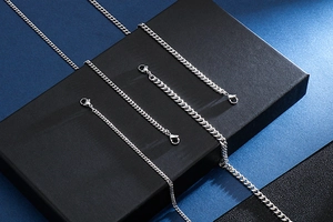 Detail of silver stainless steel Cuban link necklaces with secure lobster clasps on a jewelry box