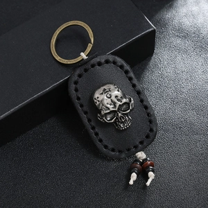 Handmade retro black leather keychain with a metal skull and woven rope detail
