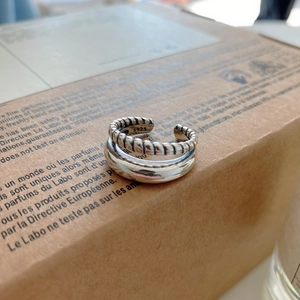 Detail shot of a double-layered S925 silver ring with twist texture on a paper box