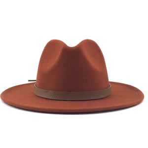 Detail van roestrode wollen fedora hoed met een bruine decoratieve band met slangenmotief