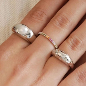 Three-piece ring set with large pearl, rainbow gemstones, and star embossing detail
