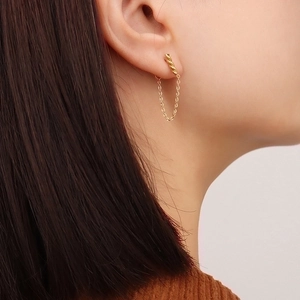 Vintage gold U-shaped spiral earrings with long chain tassel on a female model
