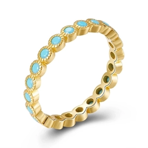 Detailed close-up of 18k gold plated eternity ring set with round green turquoise stones