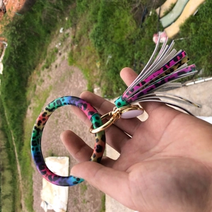 Close-up of leopard print keychain bracelet with colorful tassel and gold metal hardware