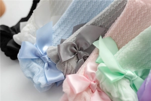 Detailed macro view of mesh knit texture and large satin bows on children socks