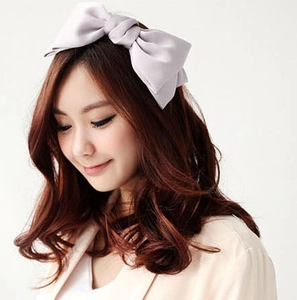 Detail view of large satin double-layered bow headband in soft dusty pink color