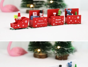 Wooden Christmas train with Santa and snowman figurines in a snowy festive scene