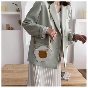 Borsa a tracolla dal design a uovo fritto indossata con un blazer casual da donna