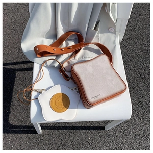 Dettaglio borsa a forma di toast con ciondolo a uovo su una sedia bianca esterna