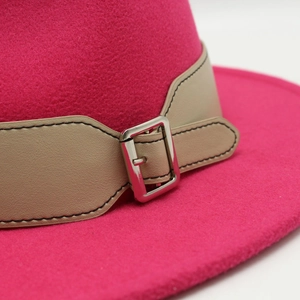 Detailed macro view of magenta wool fedora with beige leather band and silver buckle
