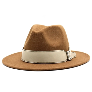 Detail view of brown wool fedora with cream leather band and silver metal buckle