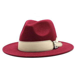 Detail of burgundy wool fedora hat featuring a beige leather band and silver metal buckle