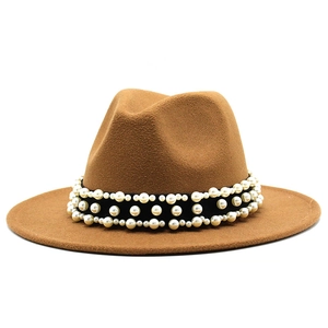 Détail du ruban gros-grain noir orné de perles blanches sur un chapeau fedora en laine
