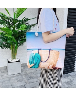 Detail of canvas tote bag with white rope handles and summer beach scenery print