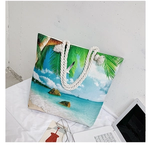 Detail of tropical beach print tote bag with thick rope handles and coastal scenery