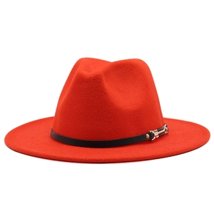 Detail of red fedora hat featuring a black leather band and metallic buckle accent
