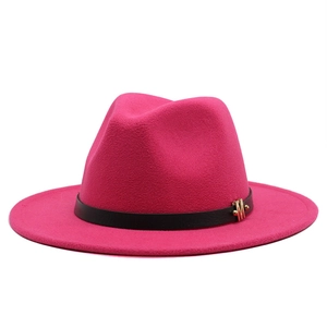 Detail of fuchsia wool fedora hat featuring a black leather band and gold M buckle