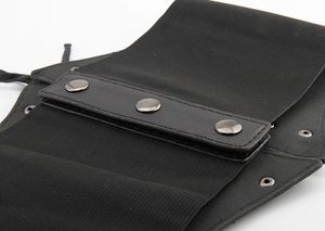 Detail of black elastic corset belt with leather panel and three metal snap buttons