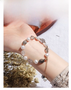 Detail of freshwater pearl and aventurine crystal beaded bracelet on woman wrist