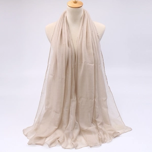 Detail of lightweight beige chiffon scarf with soft drape and breathable texture on mannequin