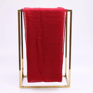 Lichtgewicht rode voile zonnebrand sjaal hangend aan een modern goud metalen frame