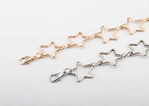 Detailed close-up of gold and silver star-shaped metal chains with lobster clasps