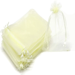 Detailed view of beige organza drawstring gift bags with gold foil Christmas patterns