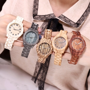 Detailed close-up of five wooden wristwatches in various natural colors and textures