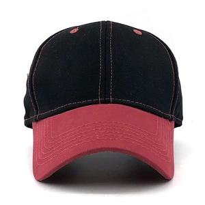 Detail of red curved brim and black cotton crown with six-row stitching on baseball cap