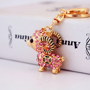 Golden zodiac sheep keychain with pink crystals and ancient coin pattern charm