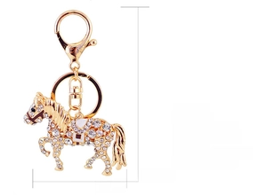 Macro detail of golden metal horse keychain with sparkling crystals and size measurements